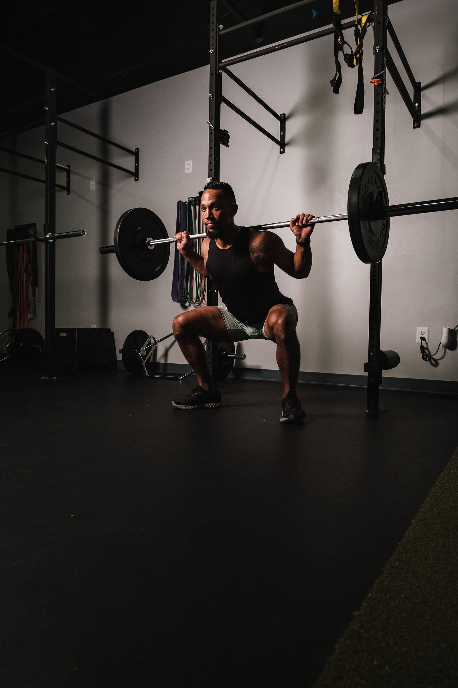 A man driving out of the bottom of a weighted squat