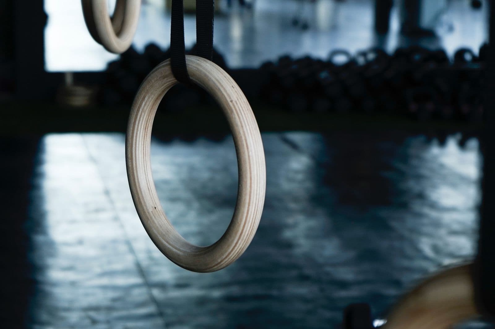 Wooden gymnastic rings hanging in a quiet gym