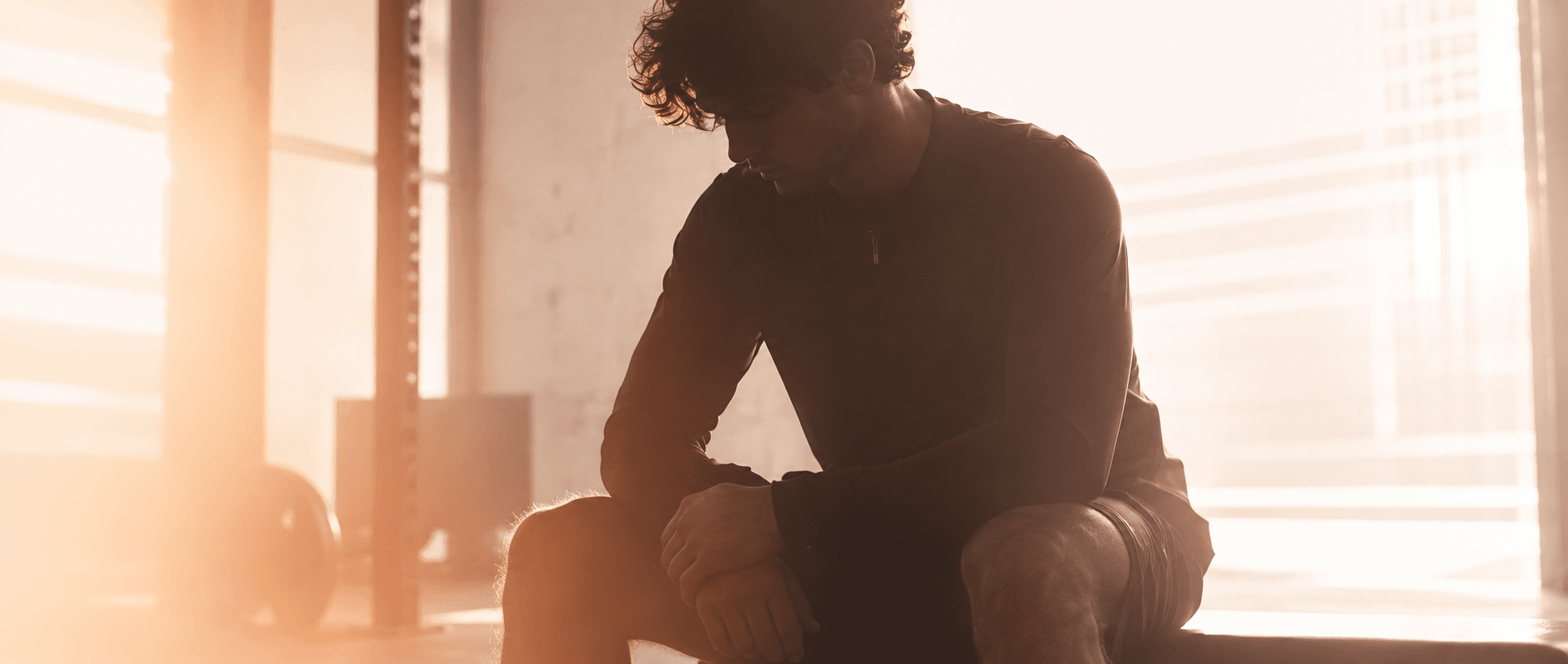 Daniel Thomas sitting mid-rest after a training session, dim moody lighting