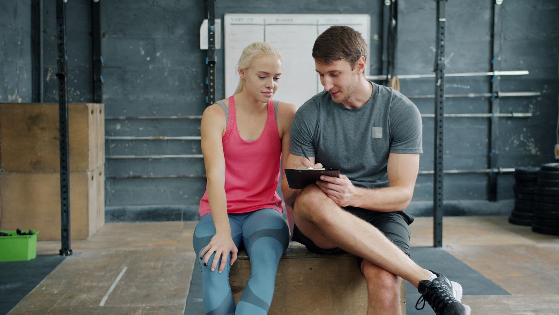 A trainer talking a client through their written plan